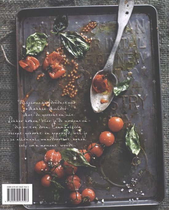 Geroosterde tomaten met basilicum en een lepel op een metalen bakplaat.