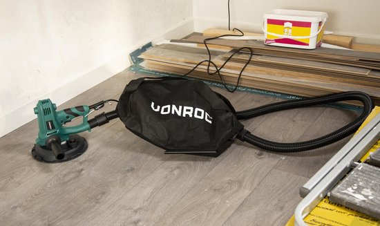 VONROC wandschuurmachine met stofzuigerslang en stofzak op een houten vloer.