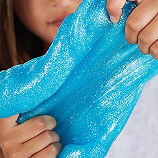 Gros plan d'un enfant jouant avec de la colle à paillettes bleue.
