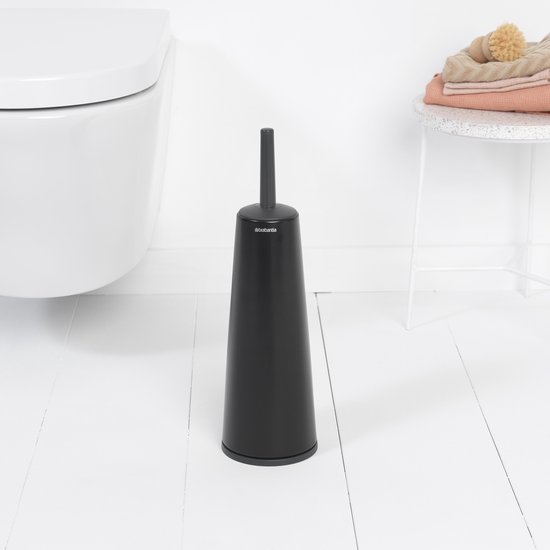 Brosse à toilettes noire avec support à côté d'une toilette, dans une salle de bain.