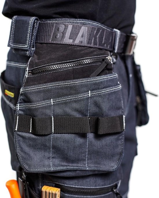 Detail van de heup van een werkjeans met een zak met rits, gereedschapslussen en een Blaklader riem.