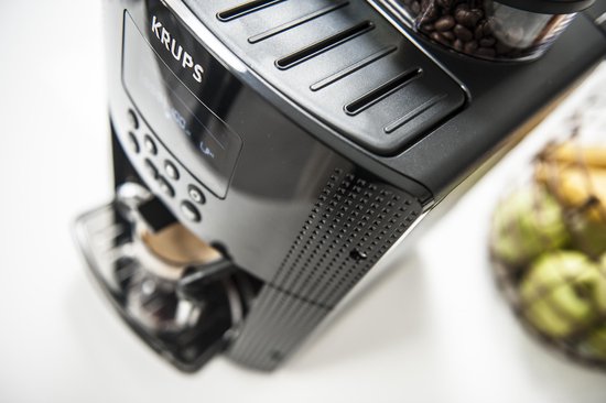 Zwarte Krups espressomachine met bonenreservoir, vanuit een schuin vogelperspectief.