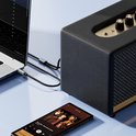 Een laptop en smartphone zijn verbonden met een luidspreker via een AdroitGoods audio kabel.