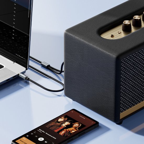 Een laptop en smartphone zijn verbonden met een luidspreker via een AdroitGoods audio kabel.