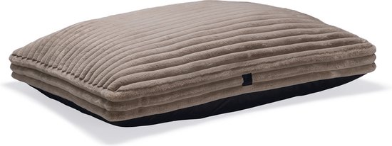 Beige hondenkussen met ribbelstructuur bovenop en een zwarte onderkant, gefotografeerd op een witte achtergrond.