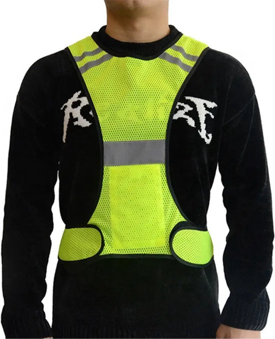 Een man draagt een lichtgeel reflecterend X-vormig vest over een zwart shirt.