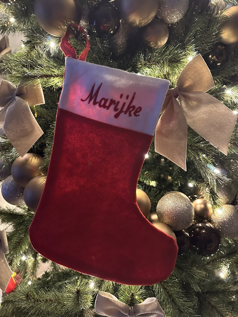 Gepersonaliseerde kerstsok met geborduurde naam in rood en groen.