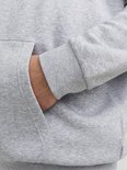 Detail van de zak en mouw van een grijze hoodie met tekst 'JACK & JONES'.