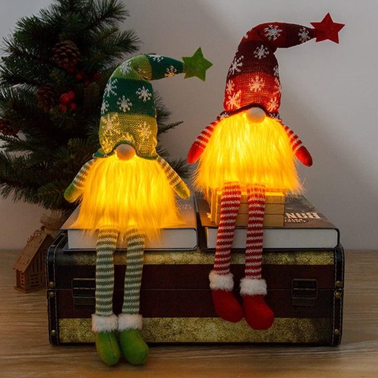 Deux gnomes de Noël éclairés, assis sur des livres. Un vert avec une étoile et un rouge avec une étoile.