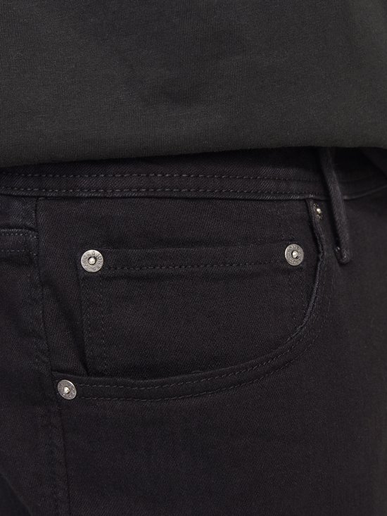 Detail van de zak en knopen van een zwarte jeans.