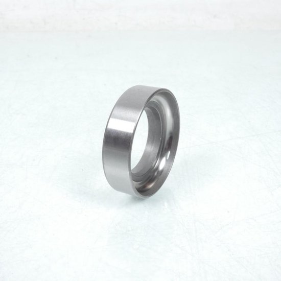 Bague métallique argentée, vue de trois quarts arrière, avec bord biseauté.