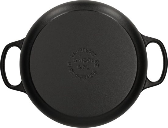 Zwarte braadpan van gietijzer, onderkant met tekst 'Le Creuset Made in France 5.1/2 Qt 5.5L'.
