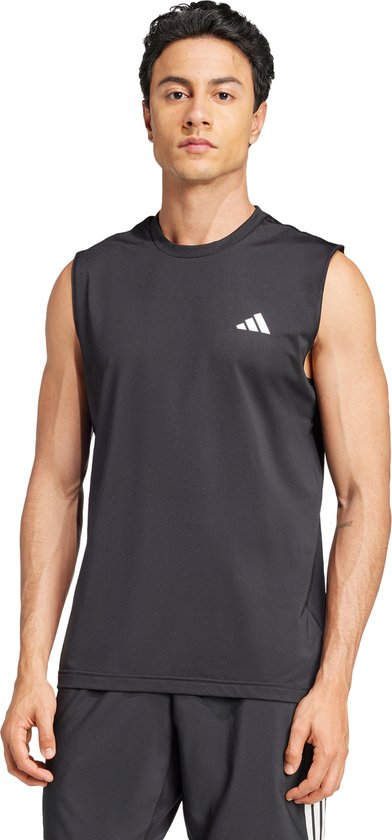 Model draagt een zwarte adidas mouwloze top met wit logo en een zwarte short.