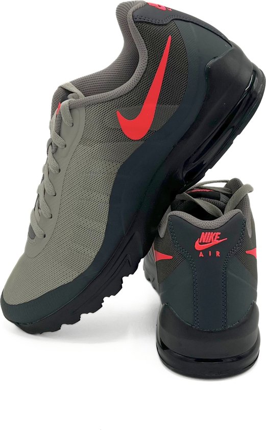 Grijze Nike Air Max Invigor sneaker met rode swoosh en 'Nike Air' opdruk.