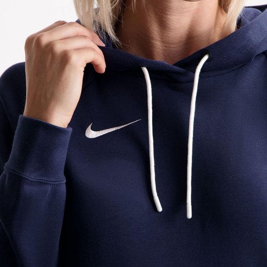 Close-up van een donkerblauwe Nike hoodie met wit Nike logo en witte trekkoorden.