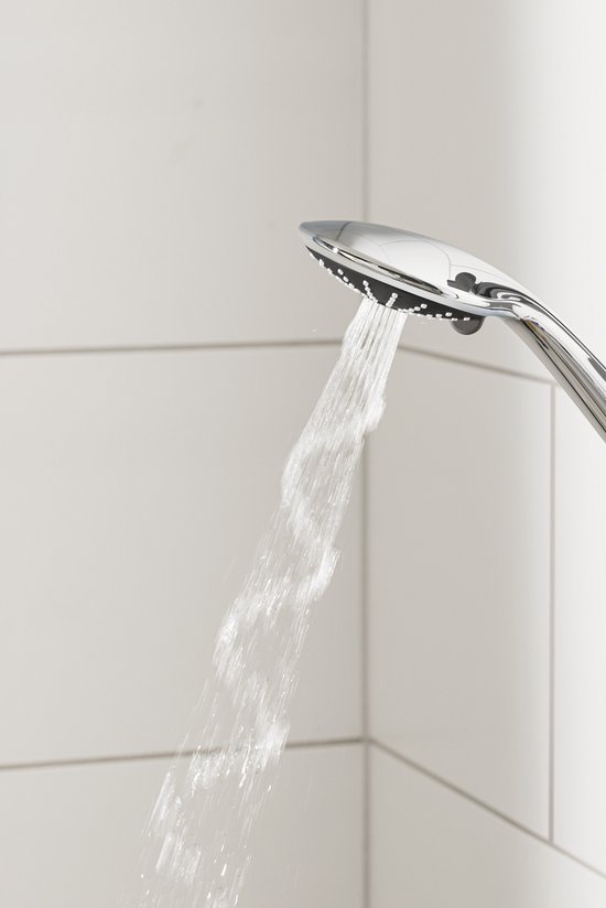 Handdouche in chroom straalt water in 'Massage' modus, tegen witte tegels.