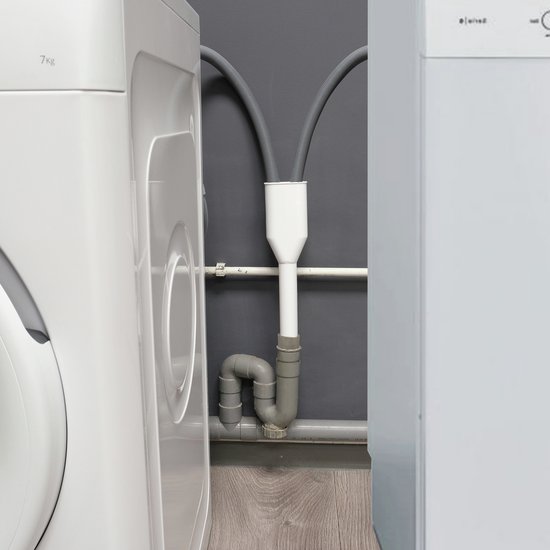 Wasmachines met grijze afvoerslangen aangesloten op een wit sifon verloopstuk bij een grijze muur.