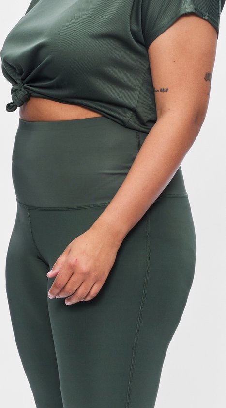Femme en tenue de sport verte, détail de la ceinture et du legging.