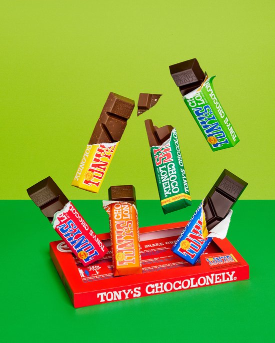Tony's Chocolonely repen met gele, oranje, groene en blauwe verpakking zweven boven een rode doos met Tony's Chocolonely erop.