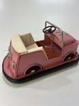 Roze retro botsauto met beige interieur, zwarte banden en zilveren details.
