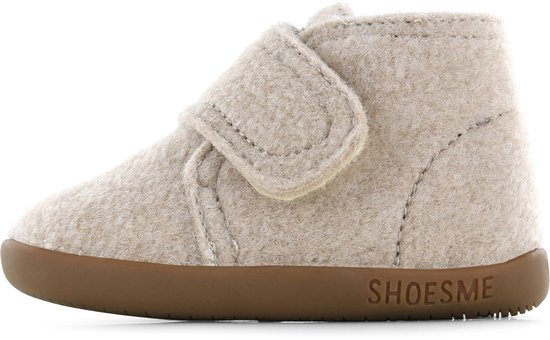 Zij-aanzicht van een beige vilten slofje met klittenband en bruine zool met 'Shoesme' logo.