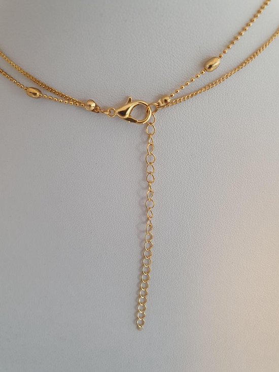 Sluiting en verlengketting van een goudkleurige dubbele ketting.