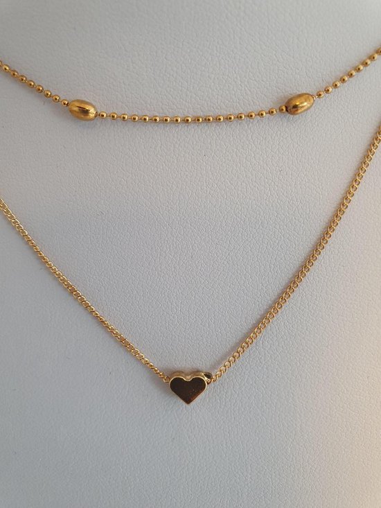 Goudkleurige dubbele ketting met bolletjes en een hartje, detail.