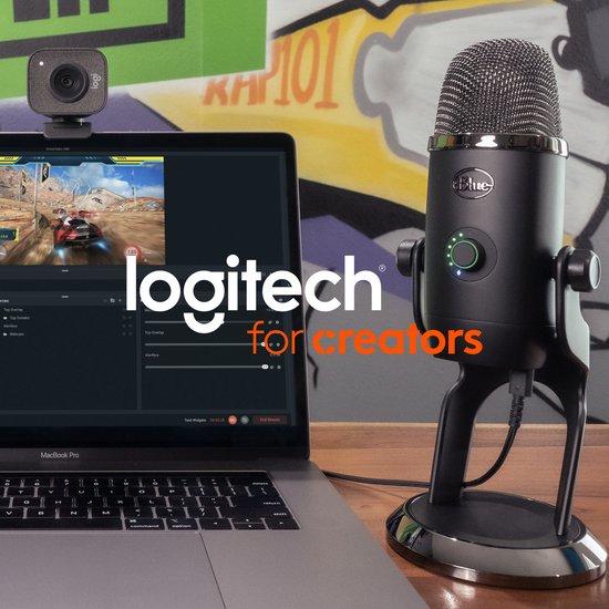 Microphone Yeti noir à côté d'un MacBook Pro affichant un logiciel de streaming et une webcam Logitech.