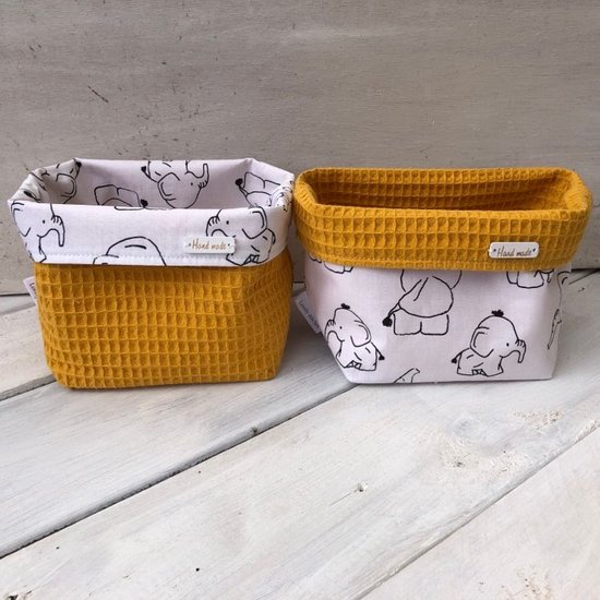 Set van twee okergele mandjes met wafelstructuur en witte binnenkant met zwarte olifantenprint. Handgemaakt labels.