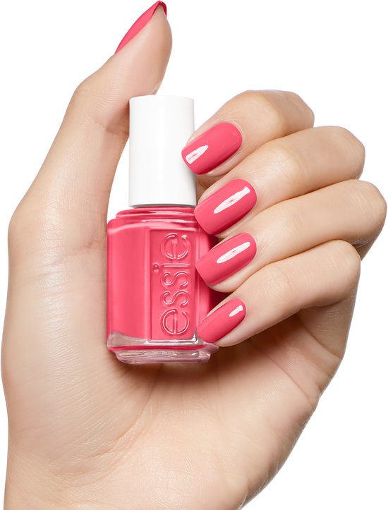 Een hand met lichte huidtint houdt Essie nagellak 'cute as a button' vast, met bijpassende nagels.