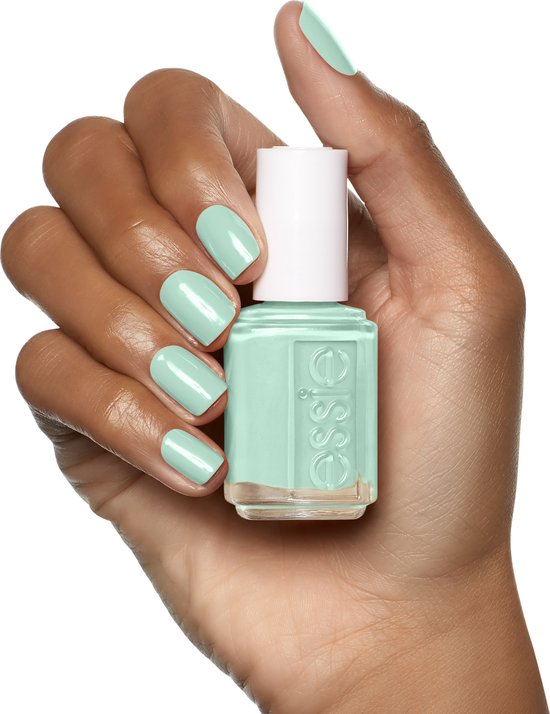 Hand met mintgroene Essie nagellak, houdt een flesje Essie nagellak vast.