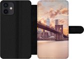 Bookcase Geschikt voor iPhone 12 telefoonhoesje - Brooklyn Brug en de skyline van New York tijdens zonsondergang - Met vakjes - Wallet case met magneetsluiting