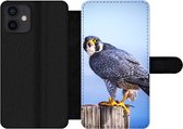 Bookcase Geschikt voor iPhone 12 telefoonhoesje - Close-up van een roofvogel op een dikke houten paal - Met vakjes - Wallet case met magneetsluiting