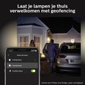 Een man stapt uit een auto bij een huis, waarbij de buitenverlichting aangaat door geofencing.