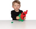 Een jongen met lang zwart shirt houdt een watermeloenvormige constructie vast, gemaakt van rode en groene Plus-Plus stukken.