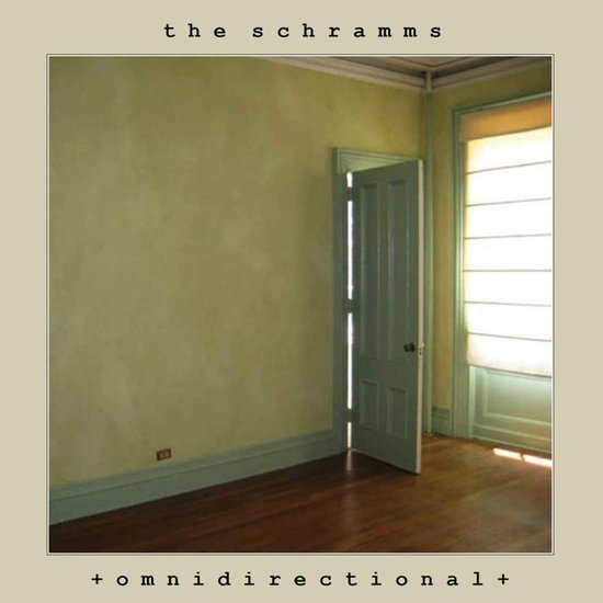 Lichtgroene muur, openstaande groengeverfde deur, houten vloer en zonlicht door een raam. Tekst: the schramms + omnidirectional +