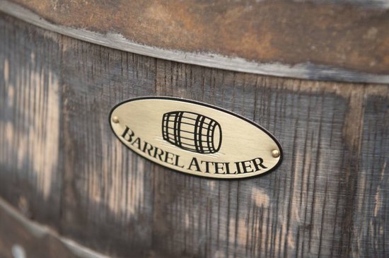 Plaque ovale en laiton avec le logo Barrel Atelier, une icône de baril et du texte.