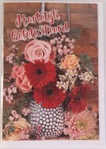 Hartelijk gefeliciteerd! Een bijzondere kaart met een mooie vaas waar ontzettend veel bloemen in staan in allerlei kleuren. Erg leuk om zo te geven of om bij een cadeau te voegen. Een dubbele wenskaart inclusief envelop en in folie verpakt.