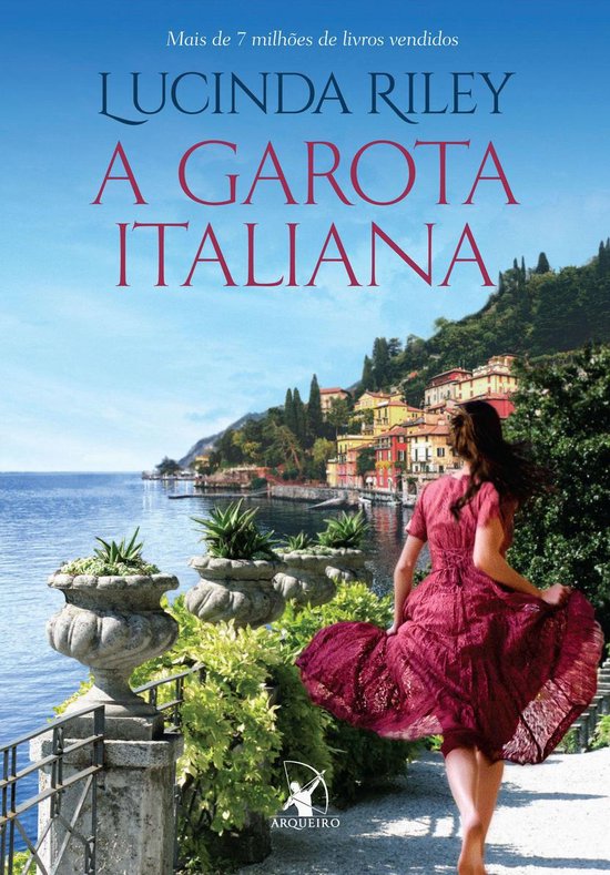 Boekomslag met de titel 'A Garota Italiana' en een vrouw in een rode jurk aan de waterkant met een Italiaans dorp op de achtergrond.