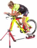 Vrouw op een gele en rode racefiets op de Feedback Sports Omnium fietstrainer.