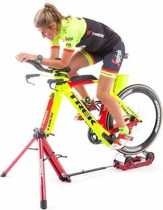 Vrouw op een gele en rode racefiets op de Feedback Sports Omnium fietstrainer.