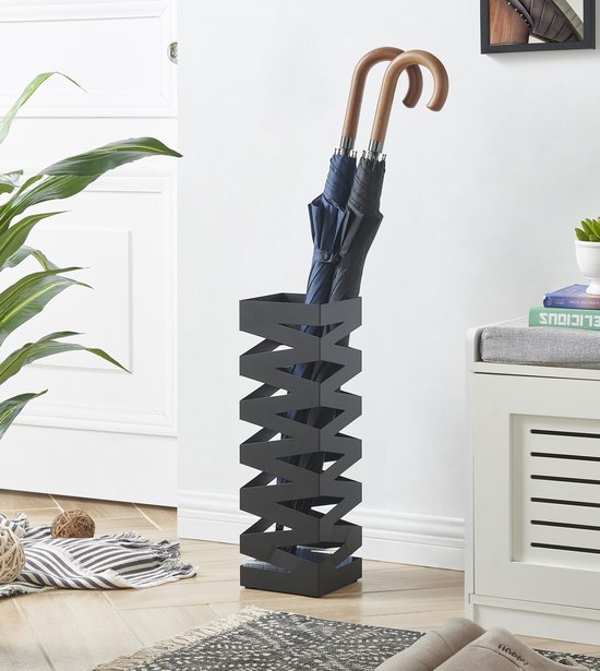 Zwarte metalen paraplubak met een zigzag patroon. Er staan twee paraplu's in met houten handvatten.