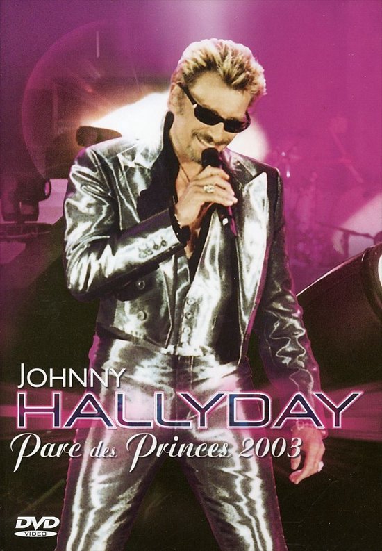 Johnny Hallyday in een glimmend zilveren pak, zingt live op het podium.