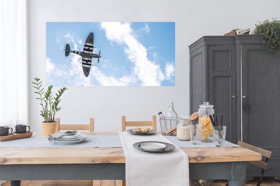 Affiche Un avion spitfire vu d'en bas dans un ciel nuageux - 160x80 cm