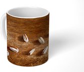 Mok - Tien zonnebloempitten op houten tafel - 350 ML - Beker