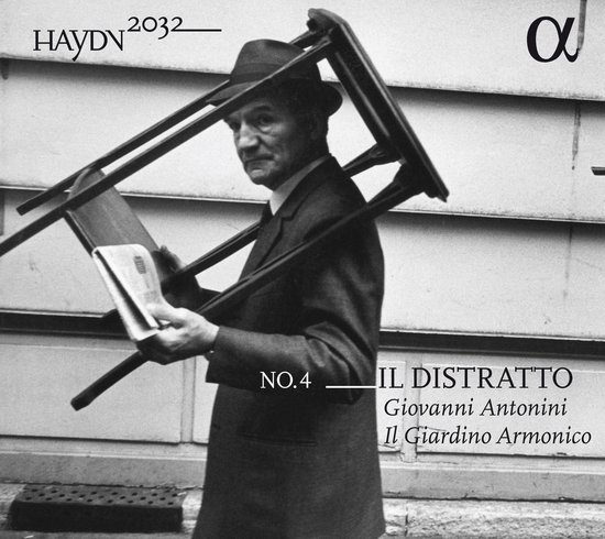 Zwart-witfoto van een man met hoed die een stoel en krant draagt. Tekst 'Haydn 2032 No.4 Il Distratto Giovanni Antonini Il Giardino Armonico'.