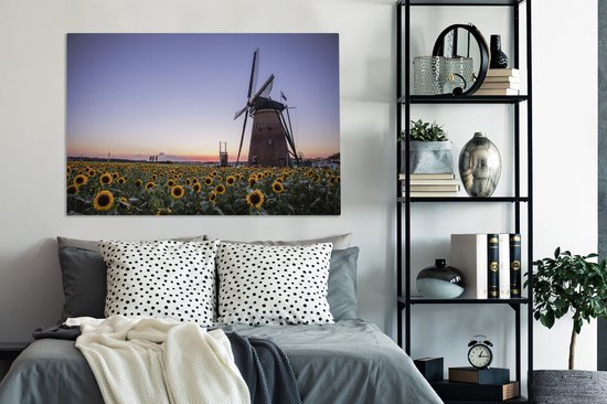 Tableau sur toile Vieux moulin à vent se dresse dans un champ avec des tournesols - 120x80 cm - Décoration murale