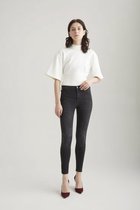 Model in zwarte Sophia skinny jeans en wit shirt met korte mouwen.