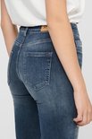 Close-up van de achterkant van een vrouw in een donkerblauwe skinny jeans met rafelige zoom. "ONLY" merklabel zichtbaar.