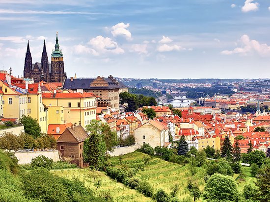 Uitzicht op de stad Praag met de Sint-Vituskathedraal en de iconische rode daken.